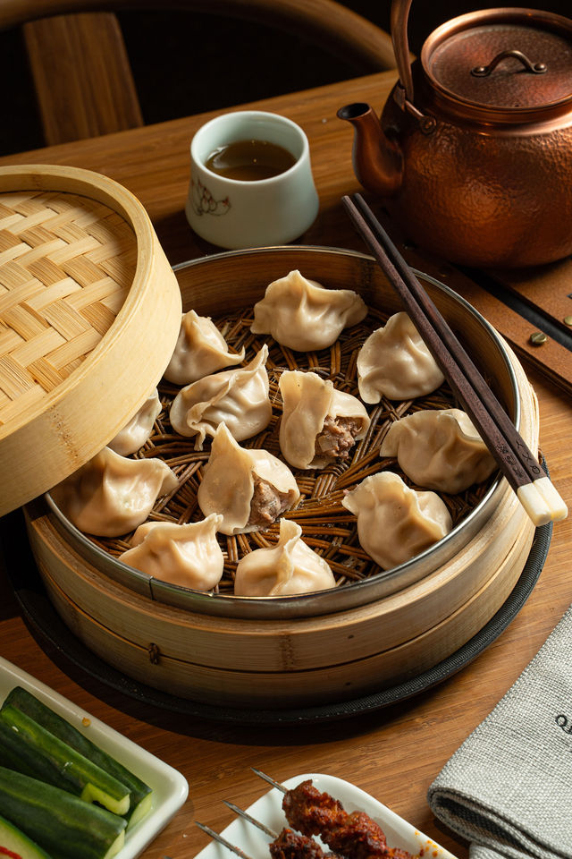 QXY dumplings served in a bamboo steamer